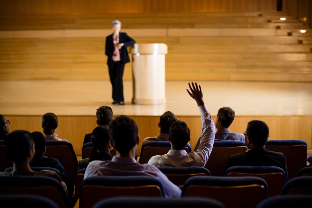 Man asking a question from woman that giving a speech